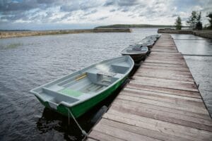 Scopri l’Argentario con il Noleggio Imbarcazioni di Franco Scotto 4 green empty boats on the lake along the wooden pie B4YF6DX
